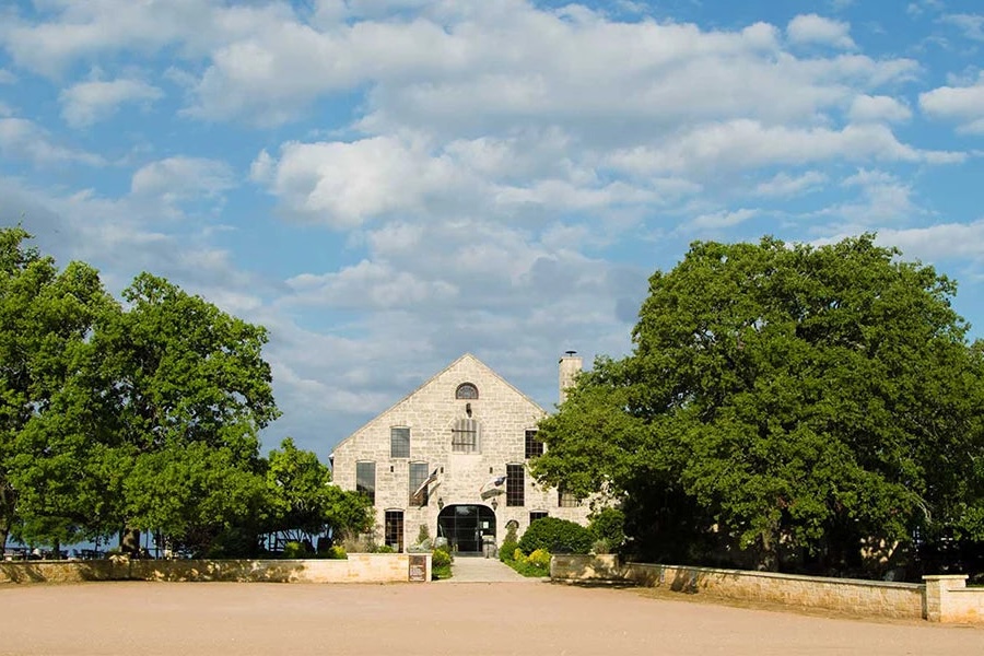 The exterior of Becker Vineyards winery, surrounded by two large trees, in Texas Hill Country
