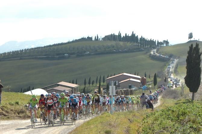 The peloton rides through the dirt roads of the Strade Bianche