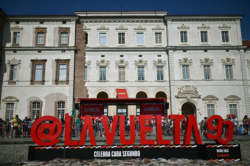The logo of &#039;La Vuelta&#039; cycling tour of Spain is seen on the podium of official teams presentation with the Reggia di Venaria Reale (Palace of Venaria) in the background, in Torino, on August 23, 2025 (Photo by Marco BERTORELLO / AFP) (Photo by MARCO BERTORELLO/AFP via Getty Images)