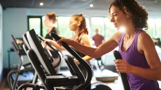 A lady uses a workout machine in the gym