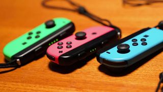 Joy Con deals - a shot of multiple coloured Joy-Cons on a wooden table