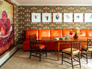 Orange sofa with plant prints, elephant and temple wallpaper