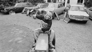 Wakeman on a compact tractor in the front yard of a house