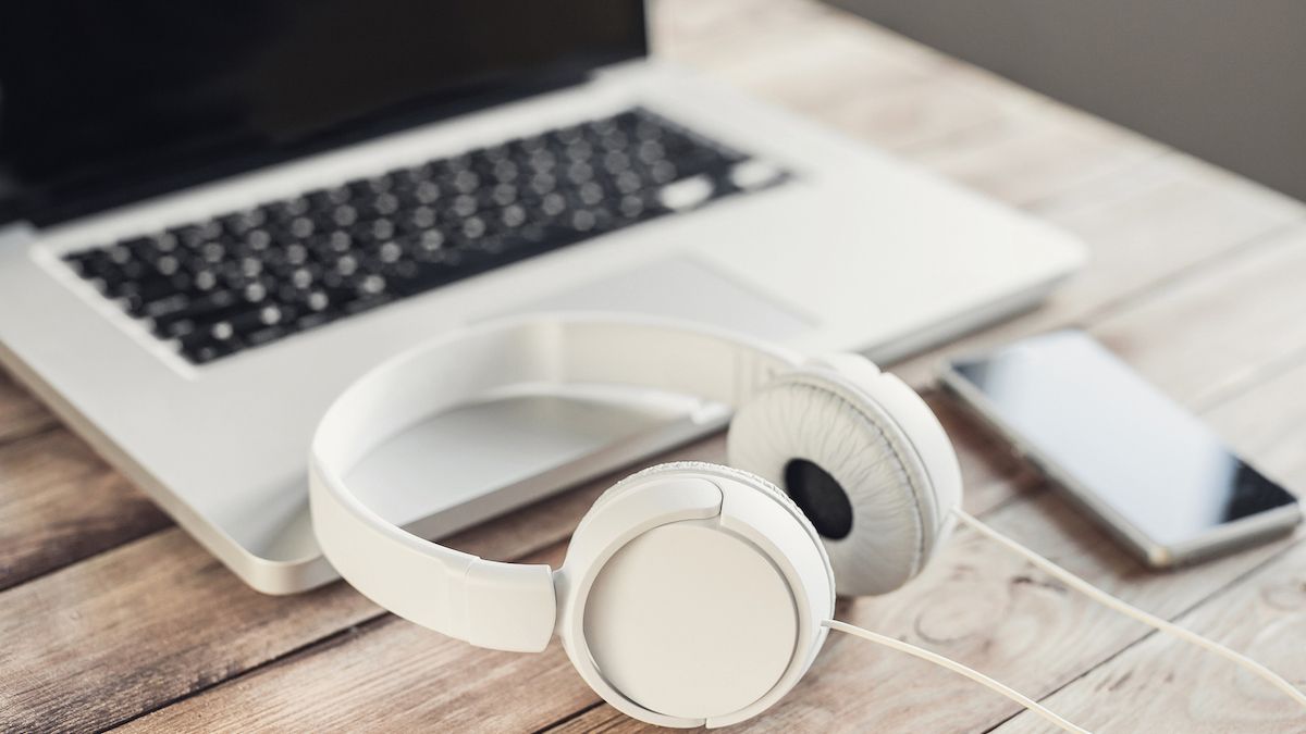 Pair of white headphones sat on a laptop