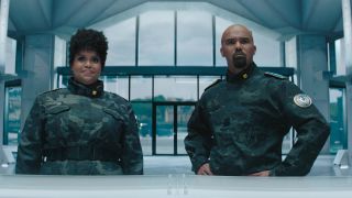 Natasha Rothwell and Shemar Moore stand in uniform in the lobby of GUN Headquarters in Sonic the Hedgehog 3.