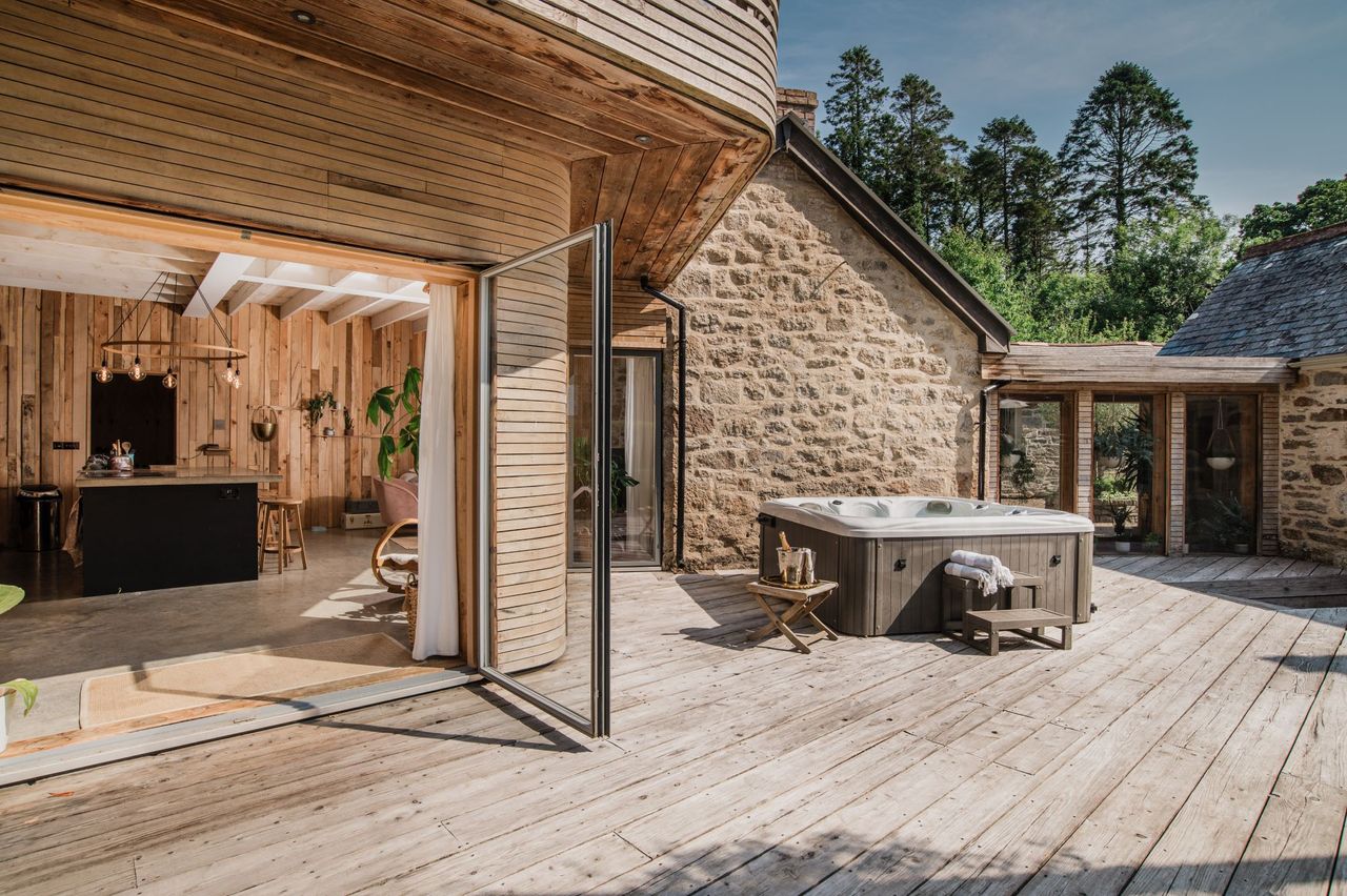 The hot tub sits next to the bifold doors of the master bedroom on the upper deck