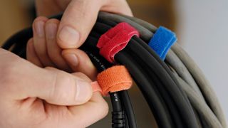 A man holding instrument cables with colored velcro wraps