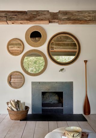 A farmhouse features minimalist, Scandinavian-inspired decor including circular rattan mirrors, wooden objects, and ceramics.