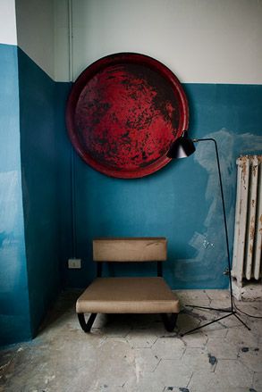red artwork on wall with black lamp