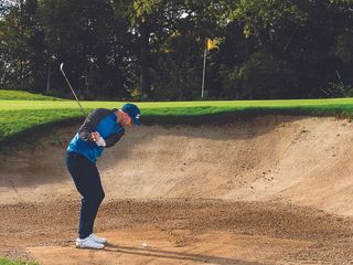 Adam Harnett hitting a bunker shot frm compacted sand in the bunker