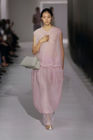 Model wearing pastel pink dress during Khaite spring/summer 2025 show.