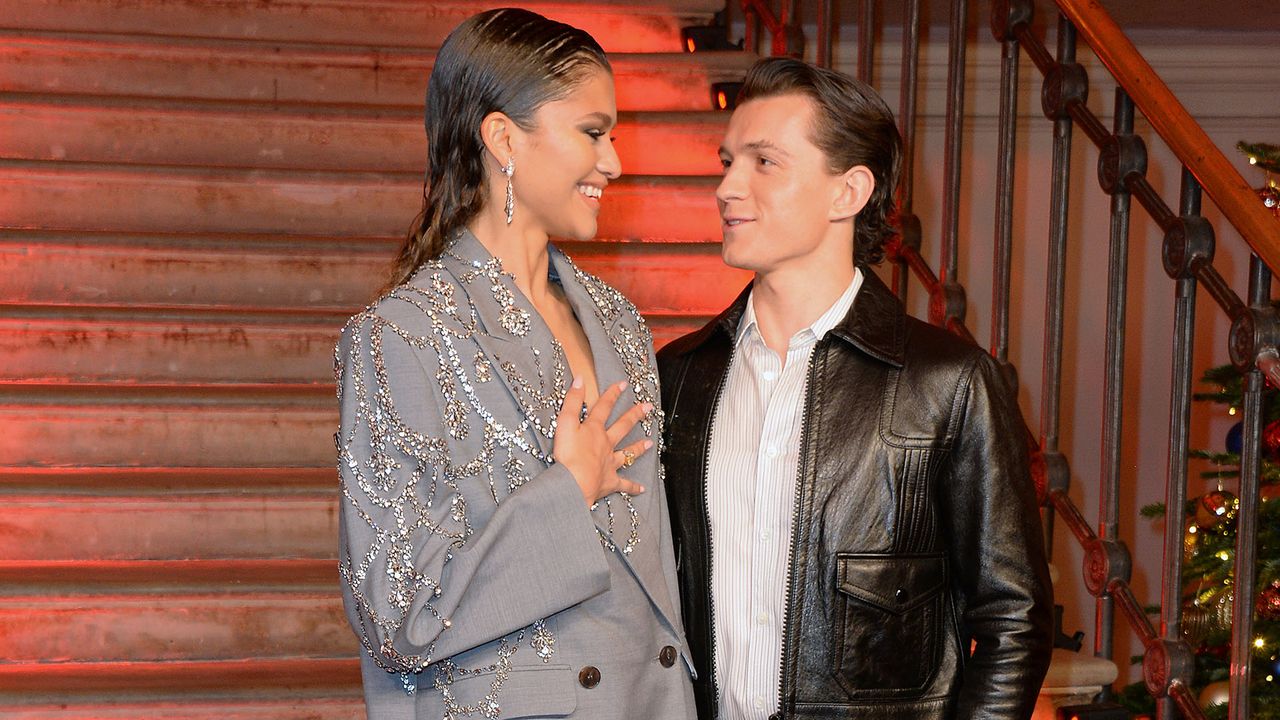 Zendaya in a bedazzled gray oversized blazer and Tom Holland in a button-shirt and fitted, black leather jacket at a Spider-Man photocall in London.