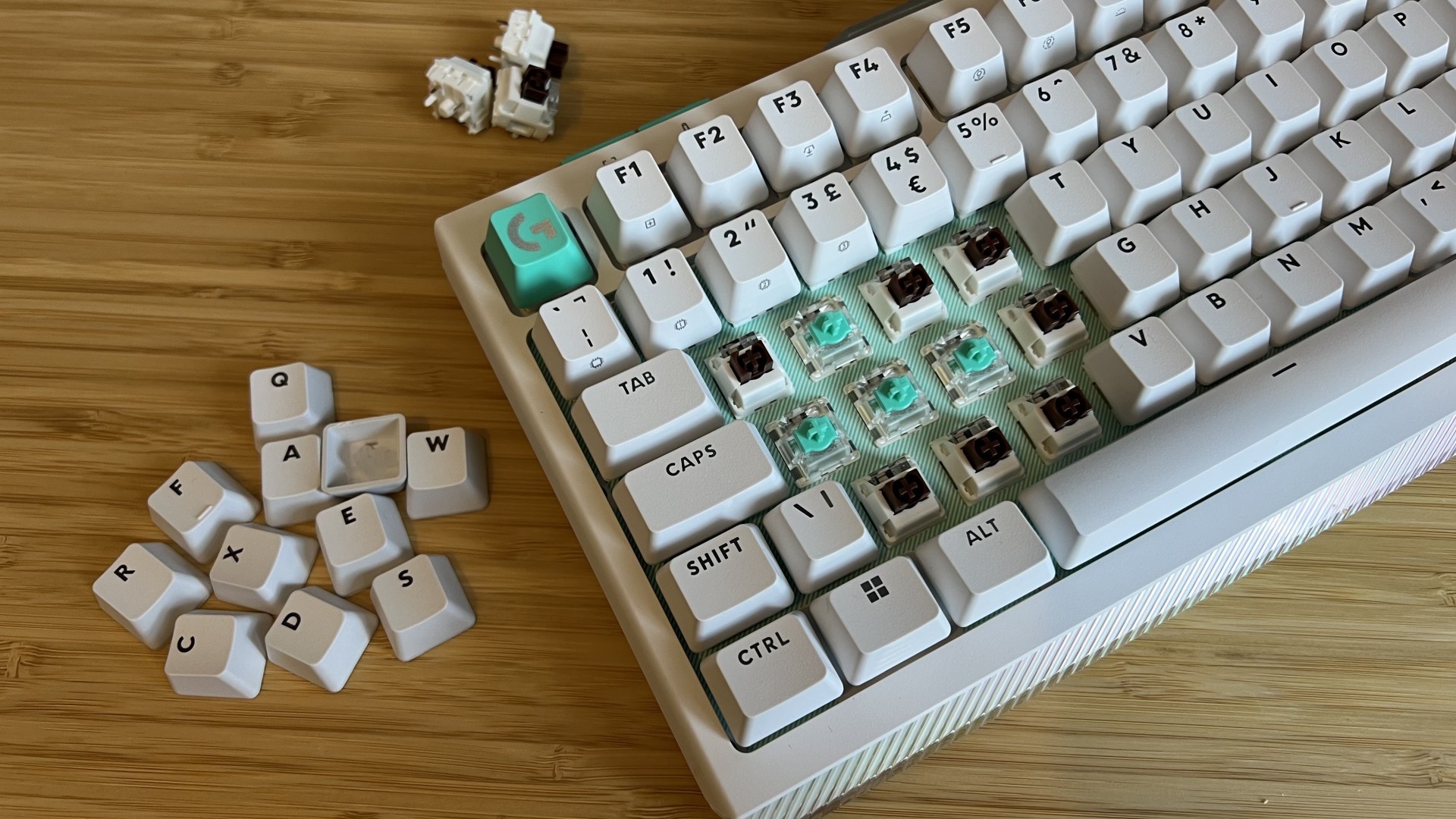 Logitech G512 X gaming keyboard with keycaps removed to show mechanical and magnetic switches underneath
