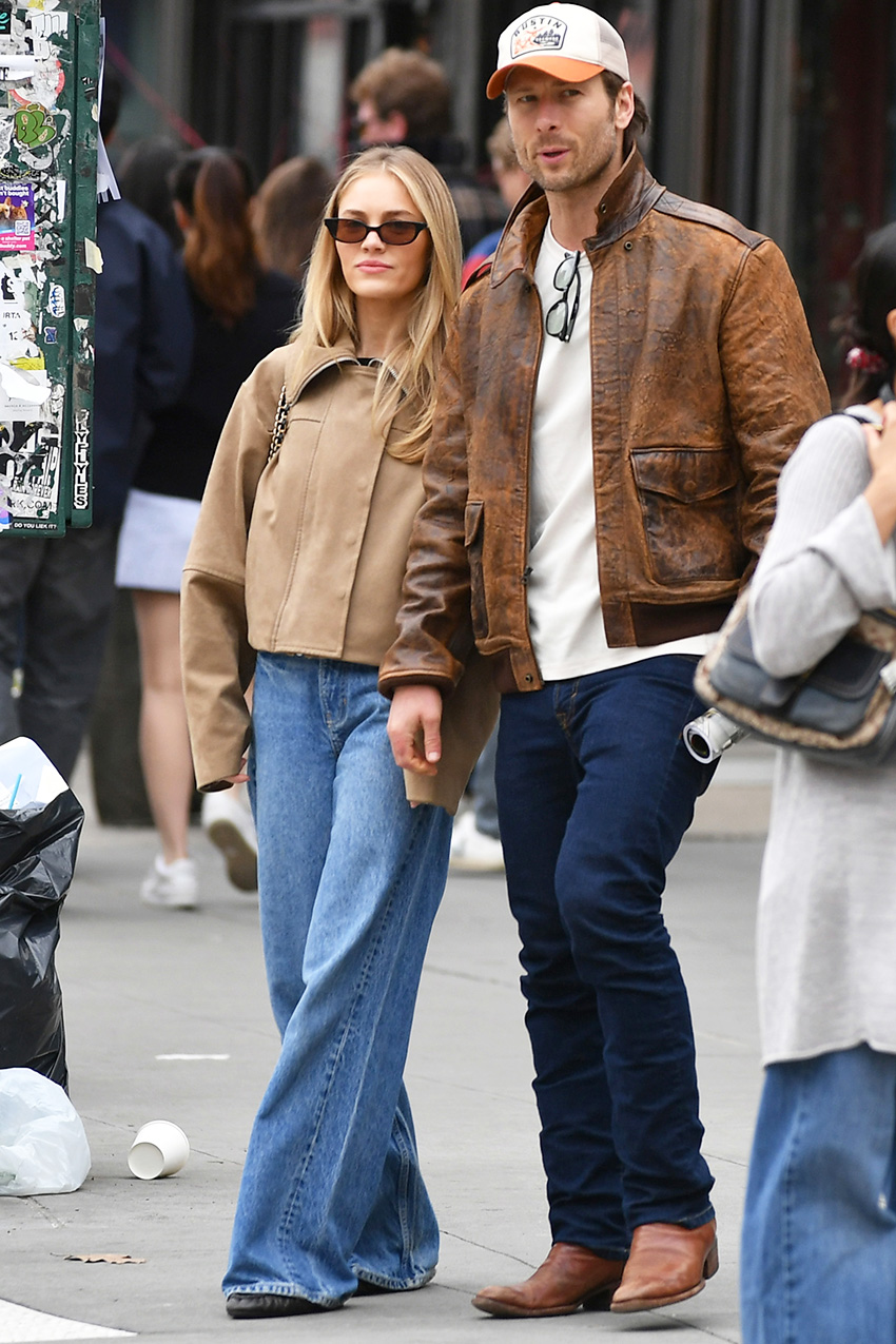 Glen Powell and Michelle Randolph walking in NYC wearing tan jackets and jeans