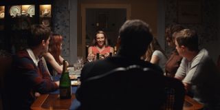 This photo shows a family dinner at the Peterson house. Kathleen (Toni Collette) sits at one end of the table, clutching a two-handled golden goblet, with a smile on her face. The rest of the family can be seen out of focus in the foreground of the picture.