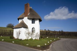 A small white tower with a thatched roof