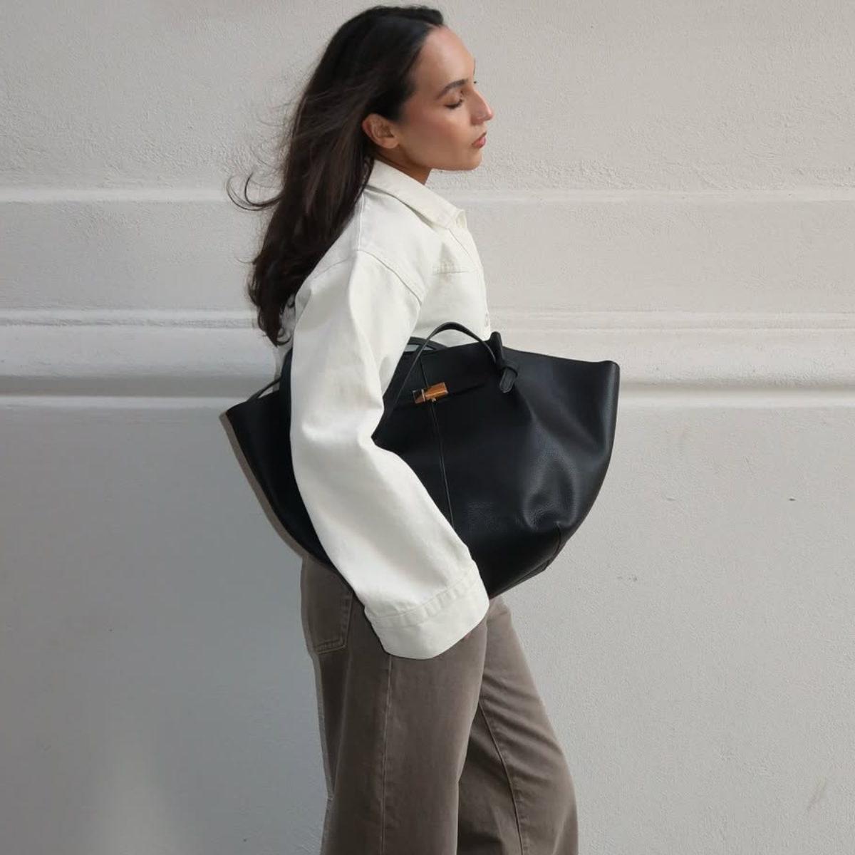 Ingrid in a white blouse and brown jeans