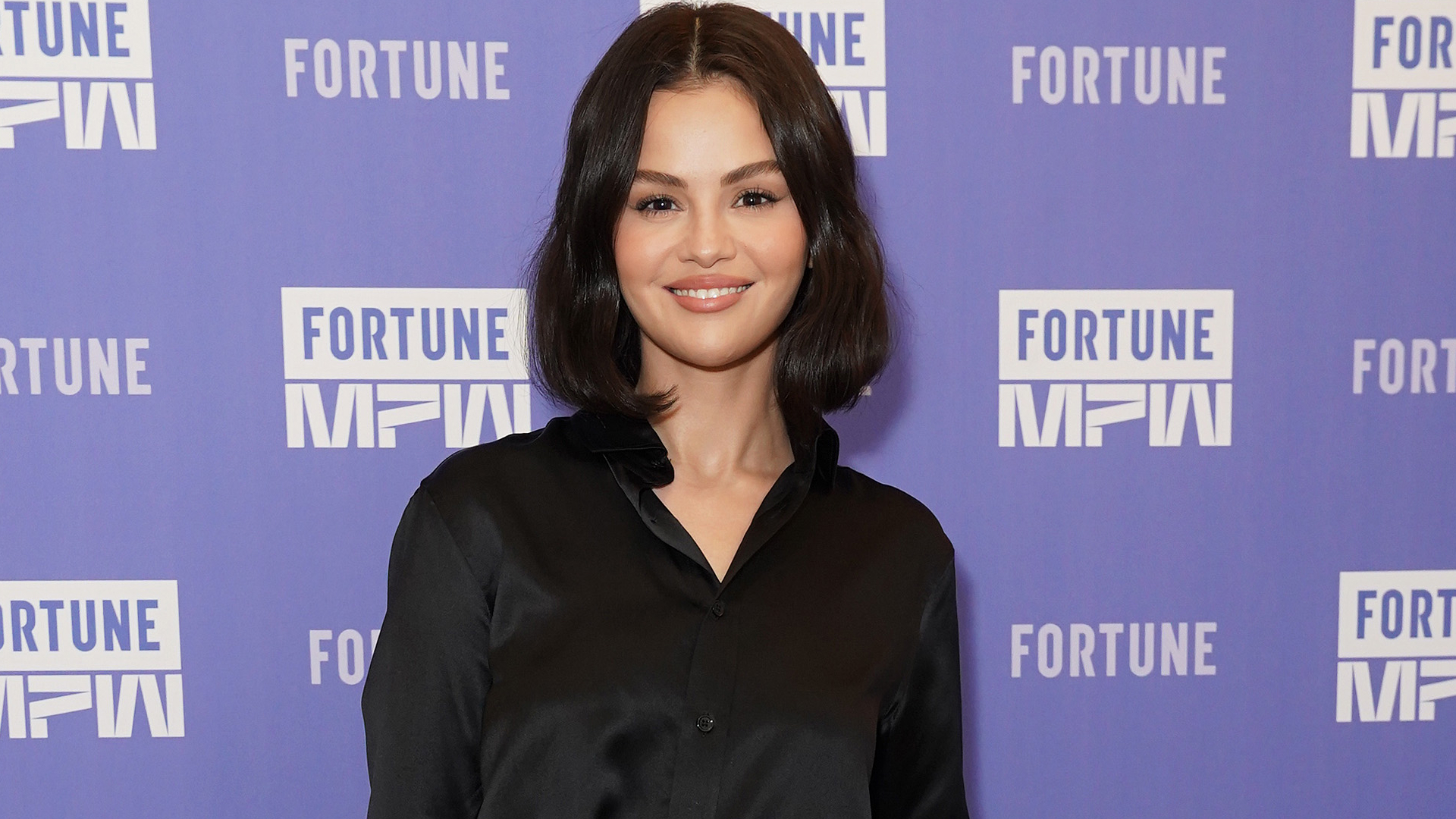 Selena Gomez on the Fortune Most Powerful Women red carpet wearing a black lilysilk shirt with nili lotan pants
