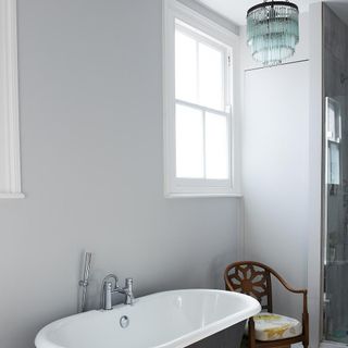 bathroom with white bathtub and chandelier