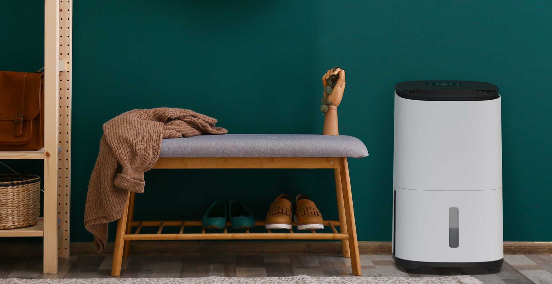 A dehumidifier standing in a green hallway next to a bench