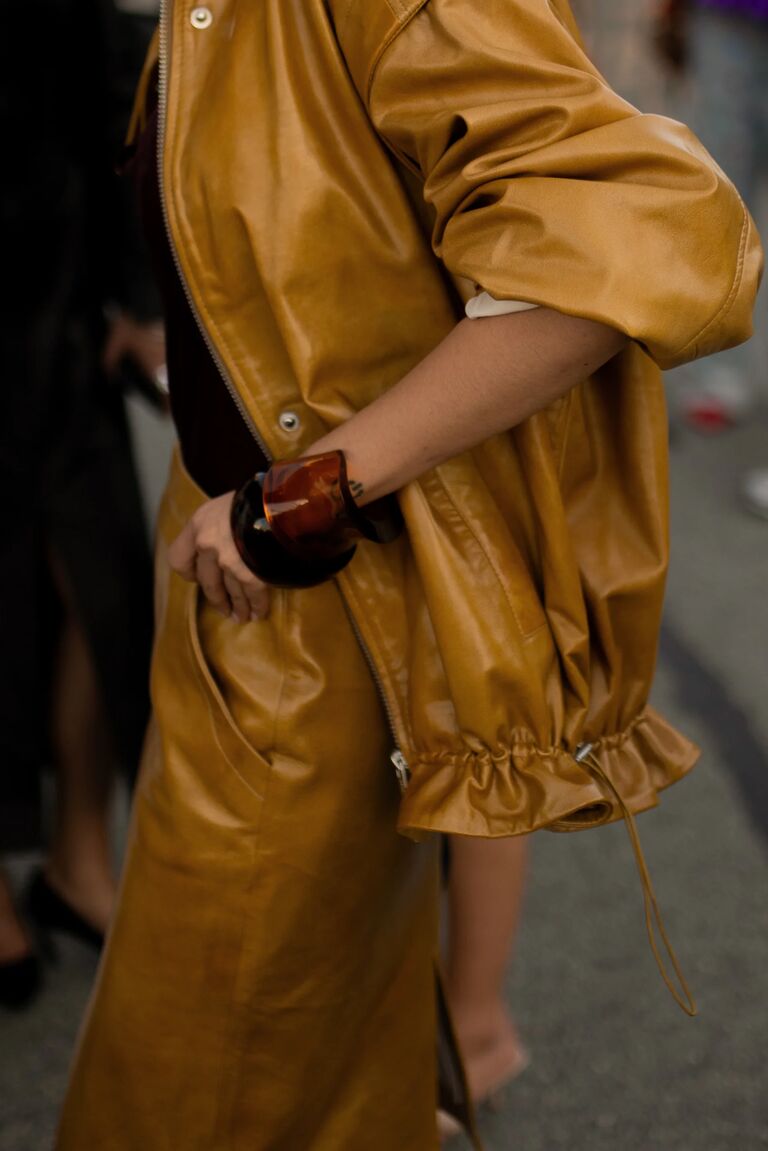 woman in mustard yellow leather jacket and skirt