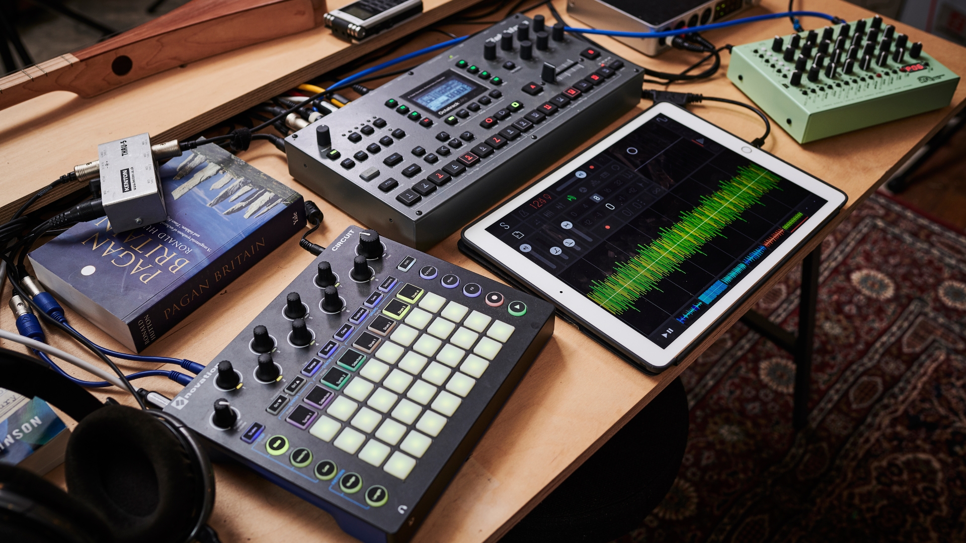 A selection of music gear on a wooden table with an iPad