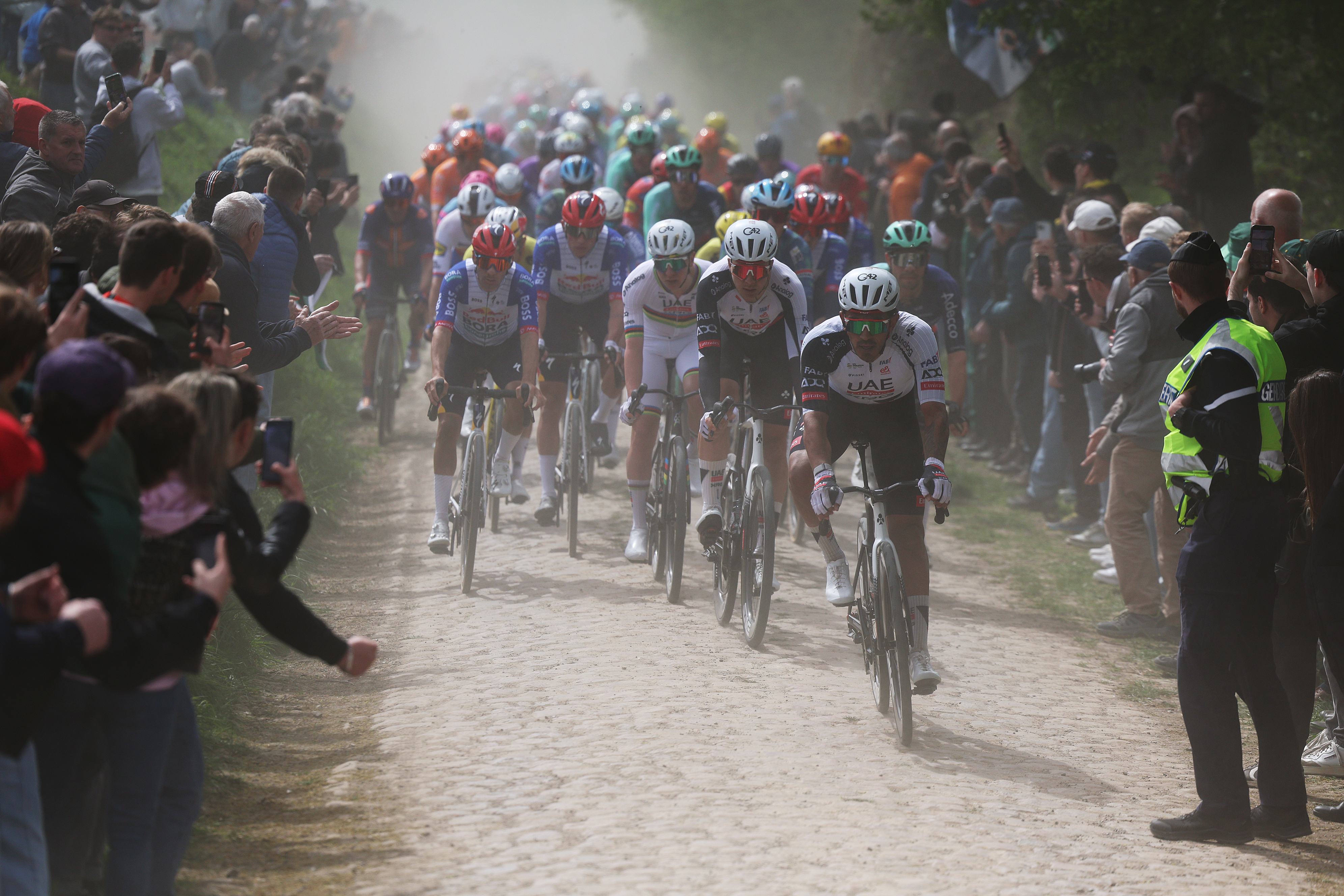 ROUBAIX, FRANCE - APRIL 12: (L-R) Tadej Pogacar of Slovenia, Florian Vermeersch of Belgium and Juan Sebastian Molano of Colombia and UAE Team Emirates - XRG lead the peloton passing through the Quievy a Fontaine au Tertre cobblestones sector while fans cheer during the 123rd Paris-Roubaix Hauts-de-France 2026 - Men&amp;apos;s Elite a 258.3km one day race from Compiegne to Roubaix / #UCIWT / on April 12, 2026 in Roubaix, France. (Photo by Rhode Van Elsen/Getty Images)