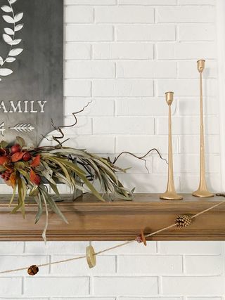Wooden fireplace mantel with garland and candlesticks
