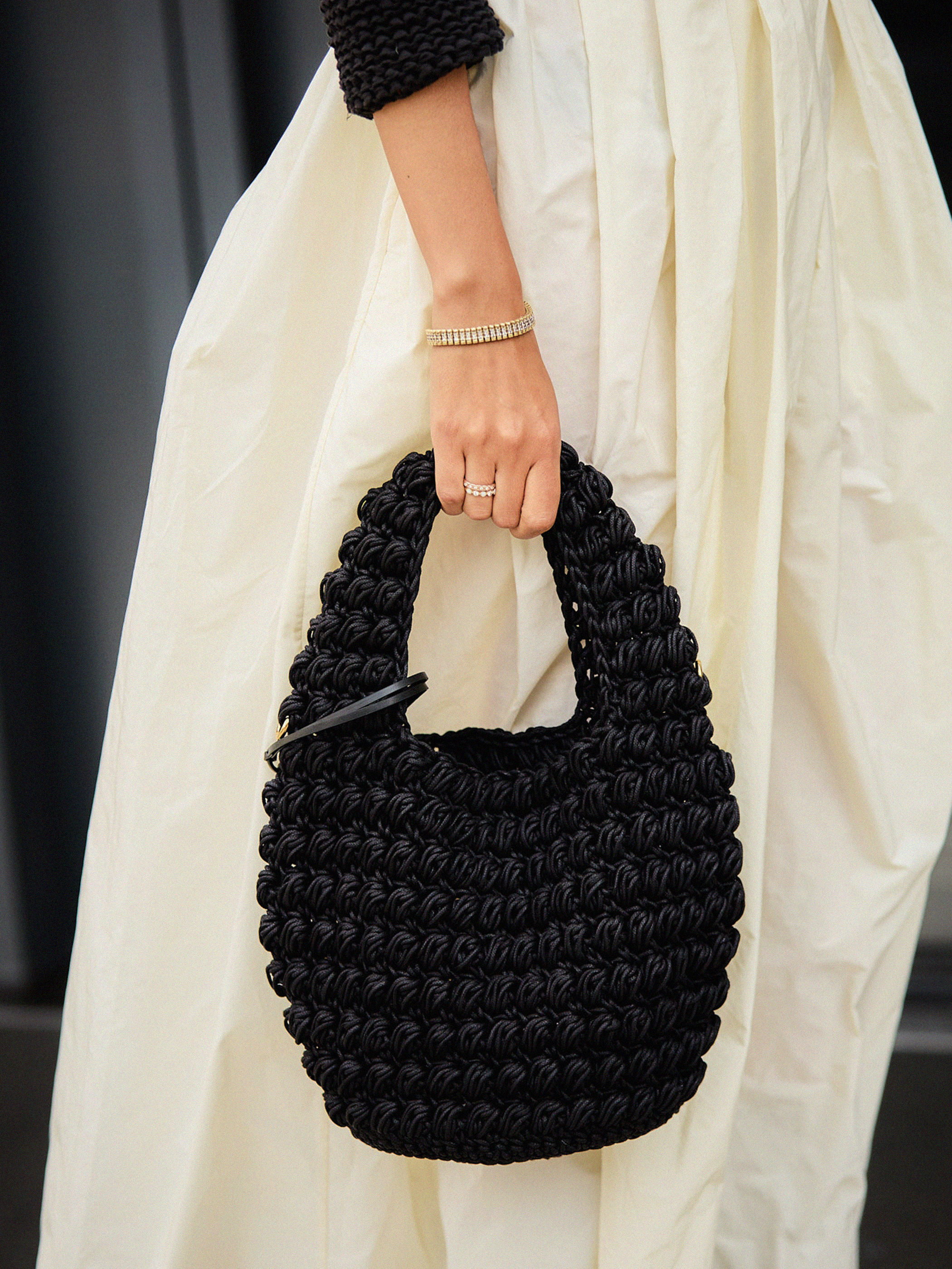 Close up of woman holding a black knit bag