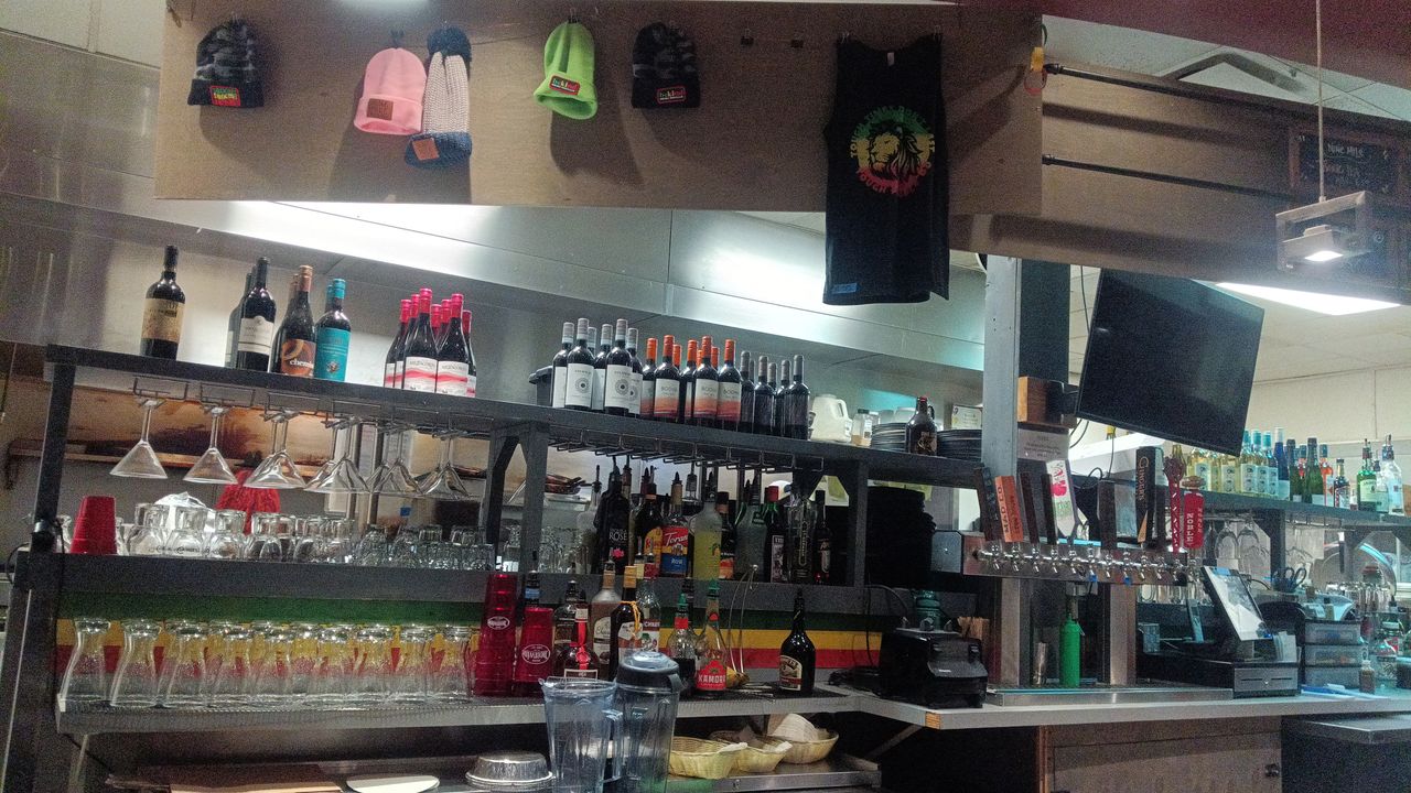 Camera samples from a Bigme HiBreak Pro E Ink smartphone showing a restaurant kitchen and bar at night