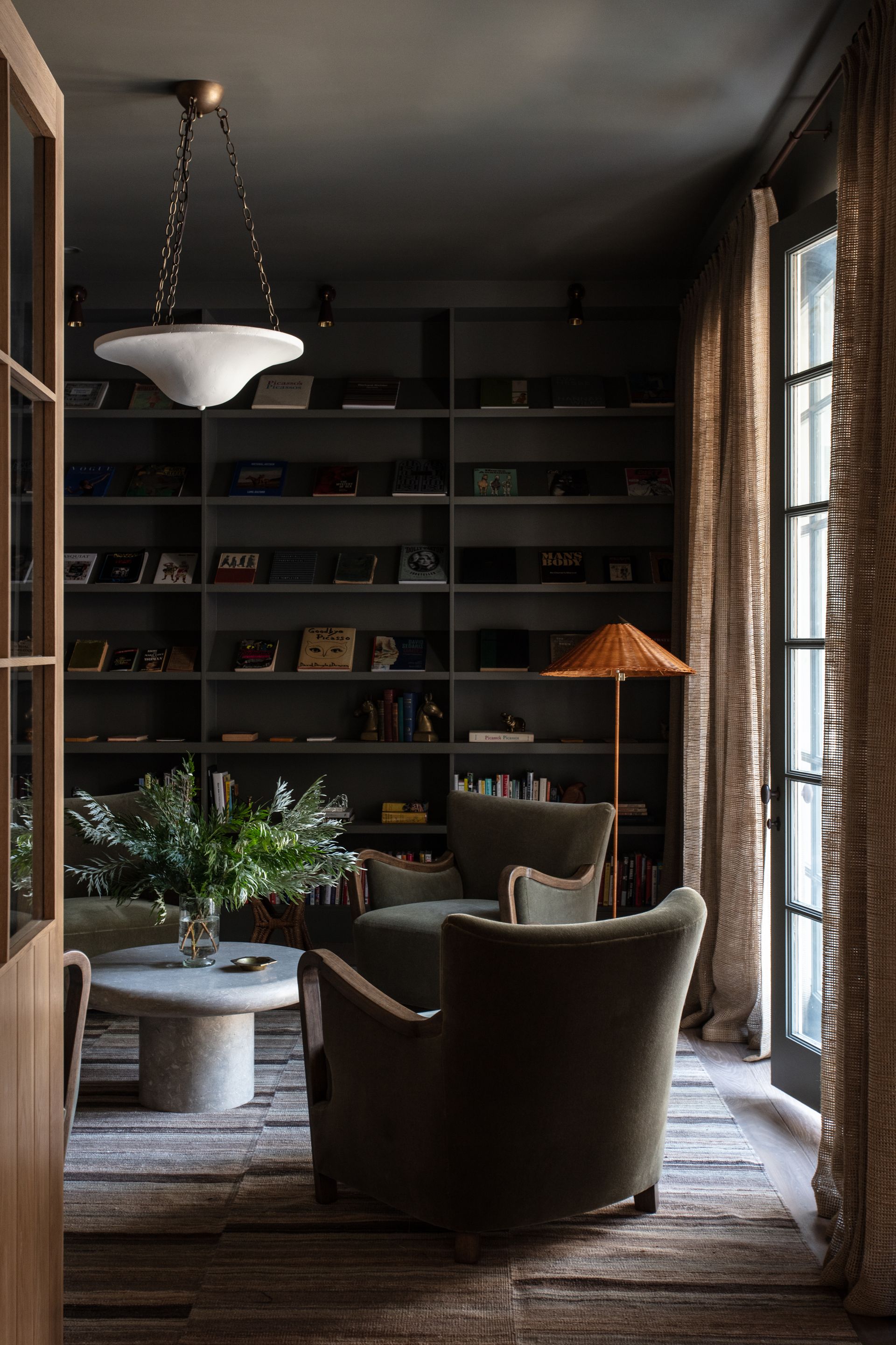 Black shelves, green armchairs, orange lamo