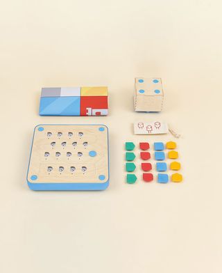 Cubetto by Matteo Loglio: the toy includes a board with slots cut onto a wooden surfaces, a wheeled wooden robot, and colourful tiles