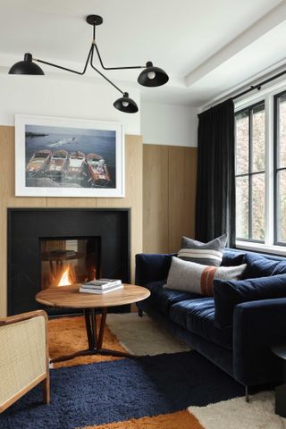 home office with blue velvet sofa bed and fireplace