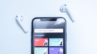 Spotify avattuna iPhonelle ja AirPodit.
