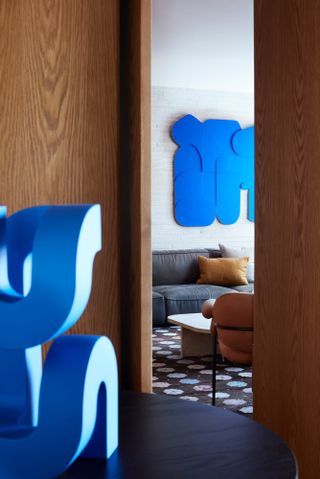 Neutral blue-toned room with bright blue wall art and sculpture