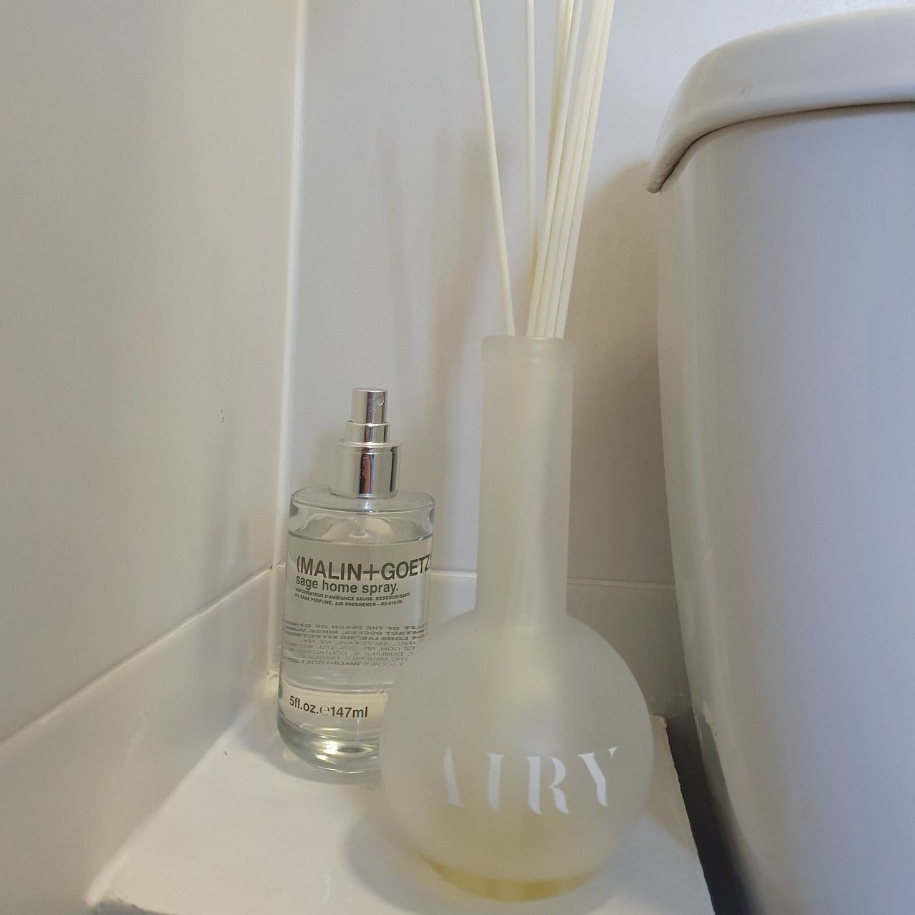 An Airy reed diffuser in my bathroom next to a Malin + Goetz room spray