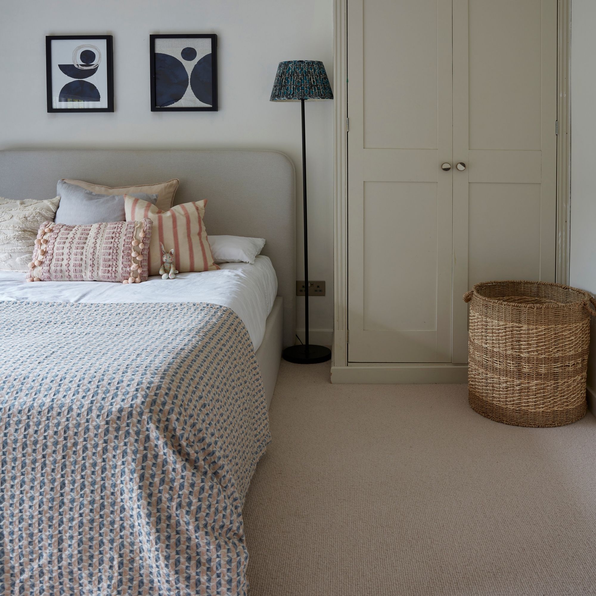 Neutral bedroom with cream carpet and bed, with cream wardrobe to the right of it