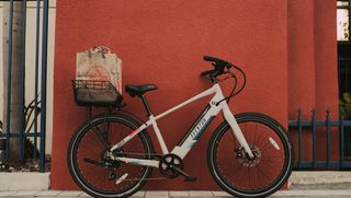An Aventon Adventure bike leaning against a wall