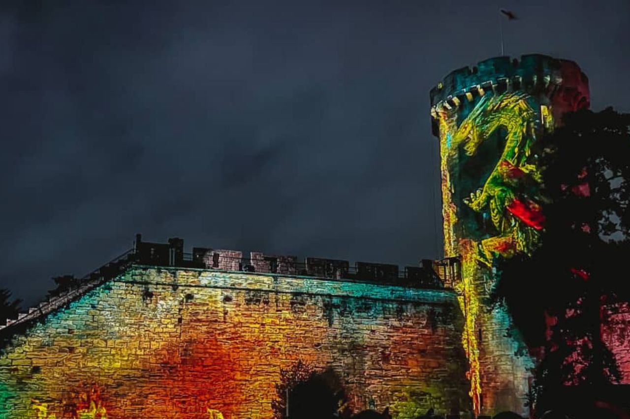 Warwick castle The Dragon Slayer illustrated by castle with projected colourful dragon on