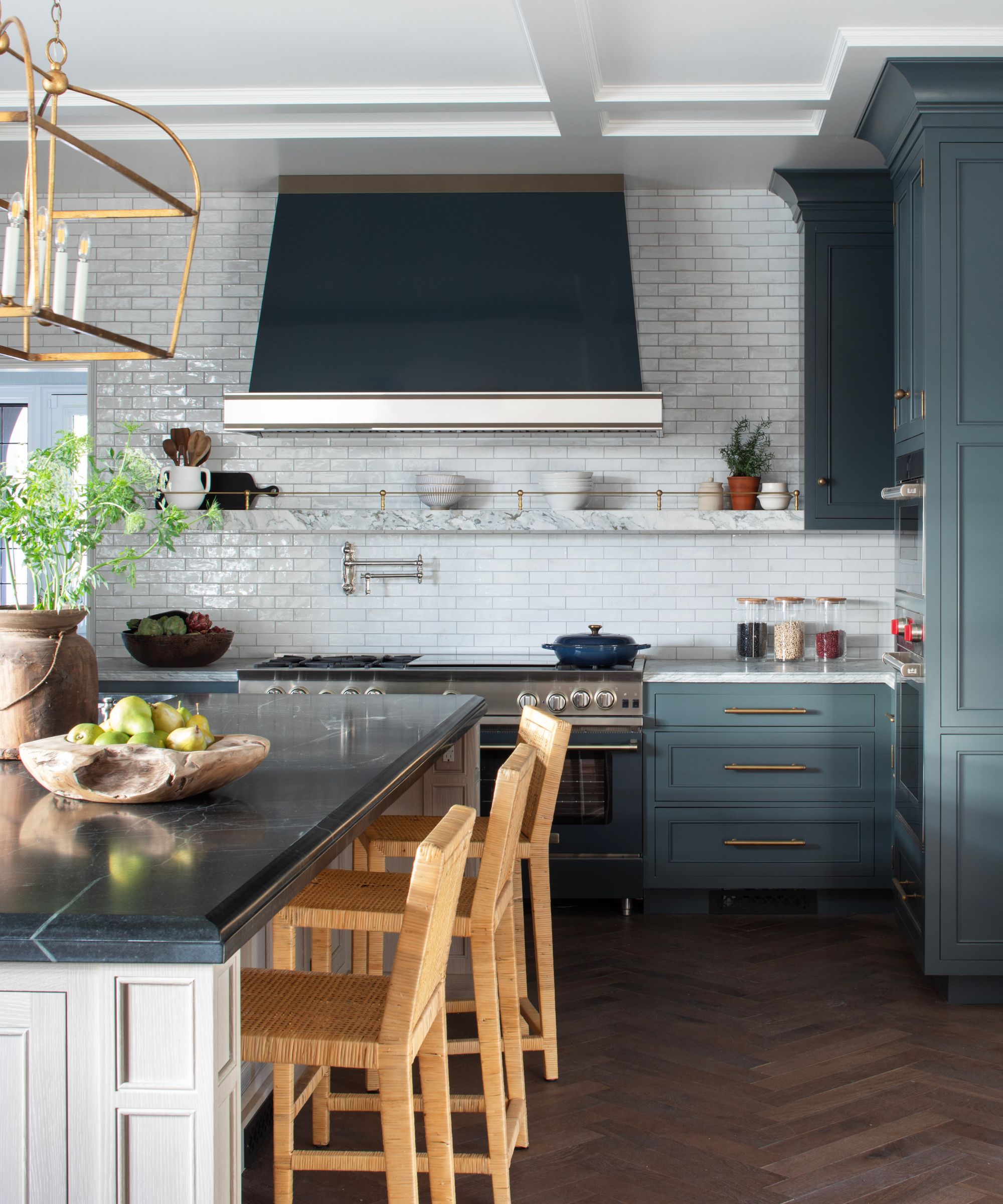 Dark gray kitchen with white subway tile backsplash and white countertops, with an island in light beige and a darker countertop