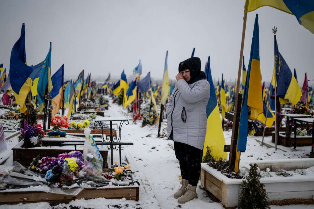 KHARKIV, UKRAINE - FEBRUARY 18: Lesia Komaritska, 41, visits the grave of her husband, who was drafted into the Ukrainian military last January 2023, and was killed in Bakhmut in February 2023, and buried in the section of the cemetery reserved for soldiers on February 18, 2024 in Kharkiv, Ukraine. Two years into Russia's full-scale invasion of Ukraine, Ukrainians are dealing with the loss of tens of thousands of soldiers and civilians, and are weary, though surprisingly resilient. (Photo by Lynsey Addario/Getty Images)