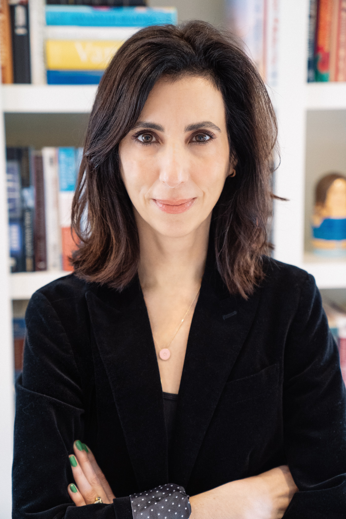 screenwriter aline brosh mckenna poses smiling with her arms crossed and wearing a black velvet suit