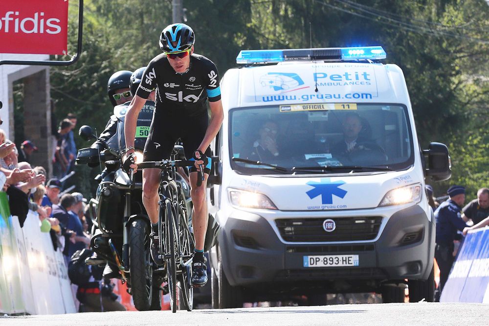Chris Froome climbs the Mur de Huy followed by an ambulance.
