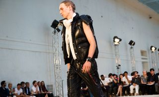 Male model wearing black clothes from the Alexander McQueen S/S 2018 collection
