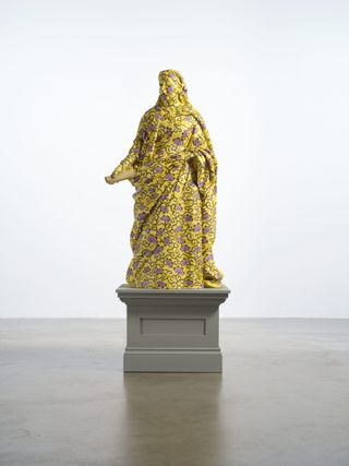 Yellow patterned statue on plinth by Yinka Shonibare