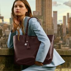 A woman modelling an Aspinal of London bag