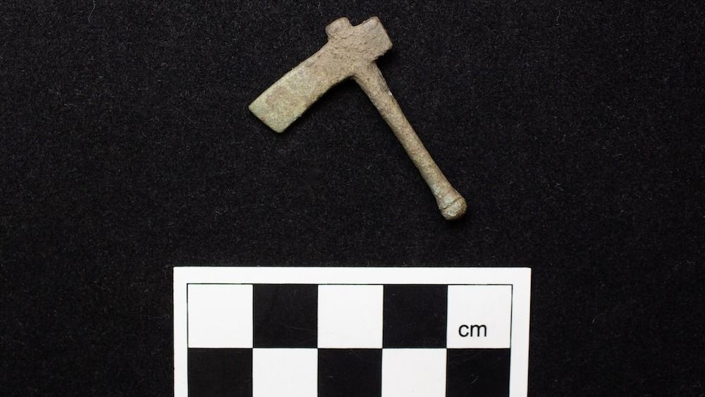 A miniature ax photographed on a black background