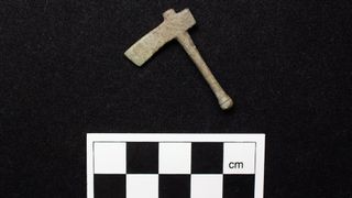 A miniature ax photographed on a black background