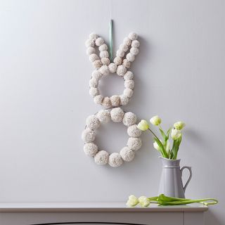 Easter pom pom bunny shaped wreath on wall