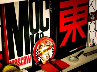 William Klein's books, including Moscow and Tokyo, displayed on shelving alongside a Dump Trump sign